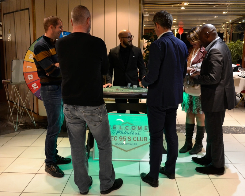 Croupier plaisantant avec joueurs de casino lors d'une soirée d'entreprise